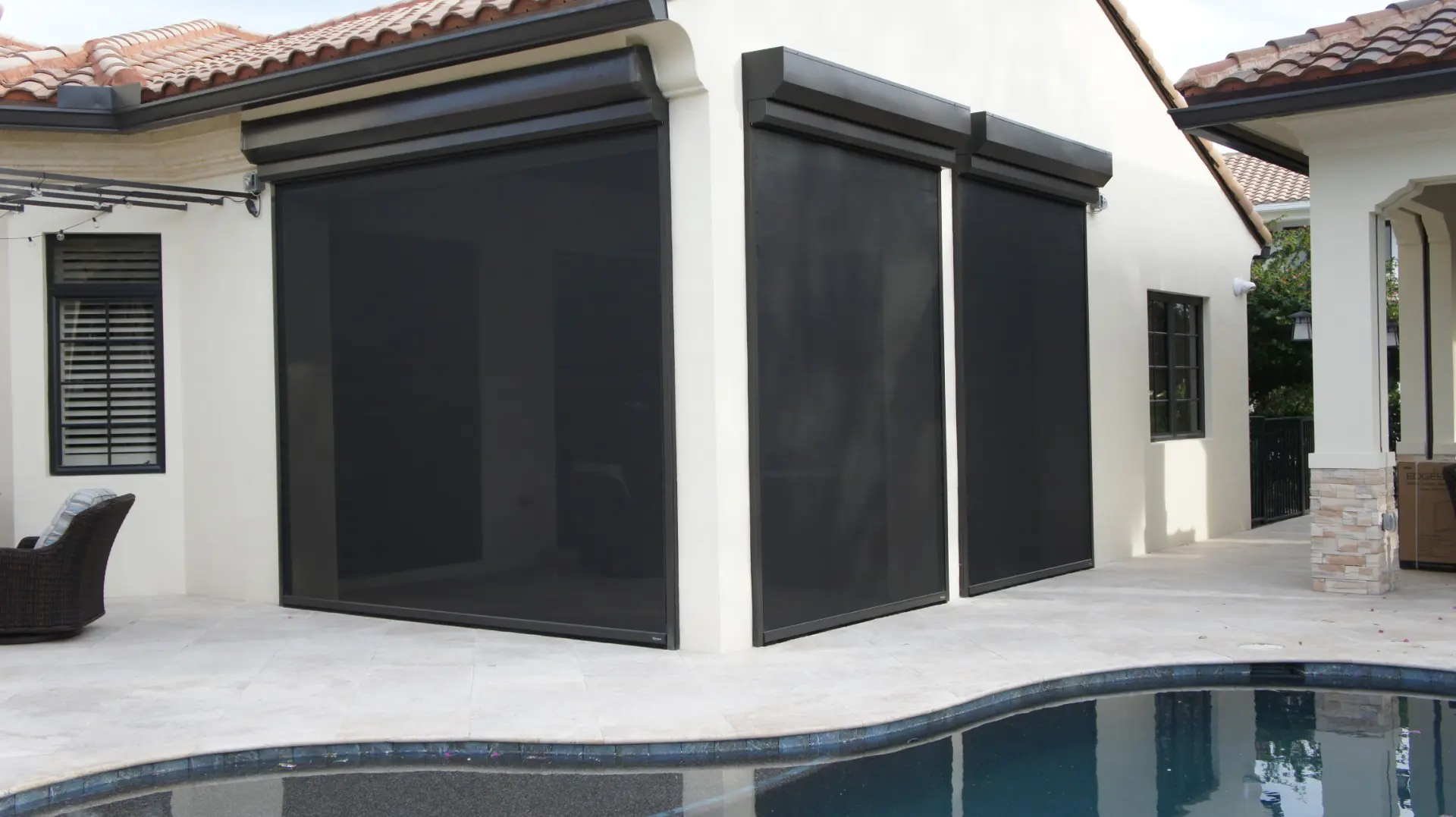 A pool with two black awnings next to it