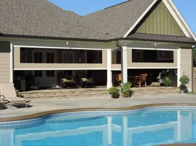 A large pool with a house in the background