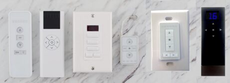 A white wall mounted light switch and remote control.