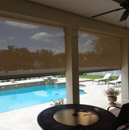 A patio with a table and chairs by the pool